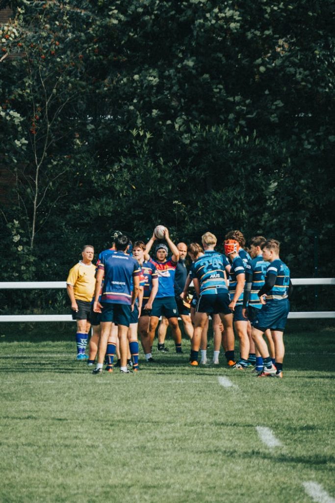 Rugby players in action during a daytime match on a grassy field.